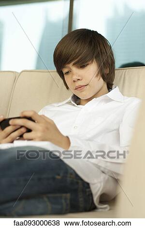 Stock Photo - Teenage boy using smartphone. Fotosearch