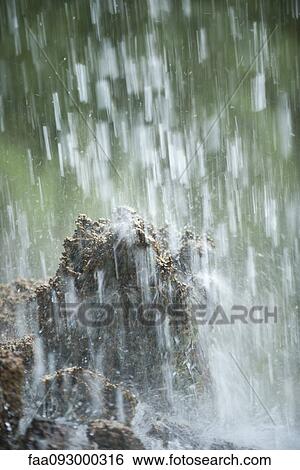 Stock Photograph - Water splashing on rocks. Fotosearch