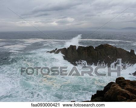 Stock Image - Waves crashing on rocks. Fotosearch