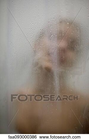 Stock Photograph - Woman behind wet glass, head and shoulders. Fotosearch