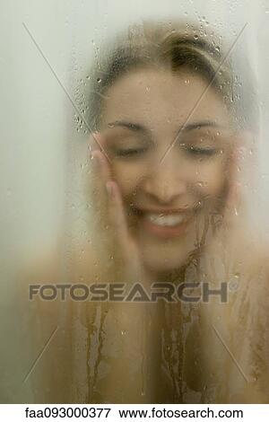 Woman behind wet glass, smiling, touching face View Large Photo Image Stock Photo - Woman behind wet glass, smiling, touching face. Fotosearch
