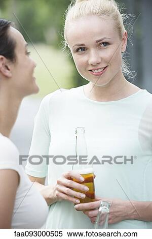 Woman chatting with friend over beer View Large Photo Image Stock Photography - Woman chatting with friend over beer. Fotosearch