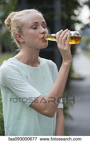 Woman drinking beer at social gathering View Large Photo Image Stock Photo - Woman drinking beer at social gathering. Fotosearch