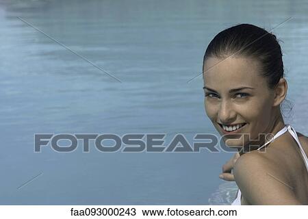 Stock Image - Woman, head and shoulders, water in background. Fotosearch