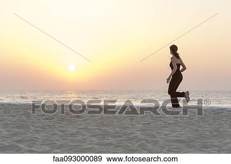 Woman jogging on beach at sunrise View Large Photo Image Stock Photo - Woman jogging on beach at sunrise. Fotosearch