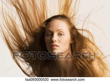 Stock Image - Woman, long hair being tousled. Fotosearch
