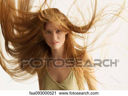 Stock Image - Woman, long hair being tousled. Fotosearch