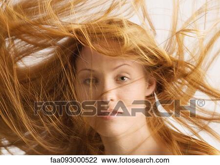 Stock Image - Woman, long hair being tousled. Fotosearch