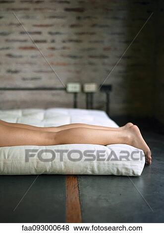 Woman lying down on futon, legs down View Large Photo Image Stock Photo - Woman lying down on futon, legs down. Fotosearch