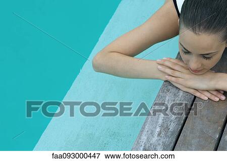 Woman lying on deck next to pool, resting head on arms, eyes closed View Large Photo Image Stock Photo - Woman lying on deck next to pool, resting head on arms, eyes closed. Fotosearch