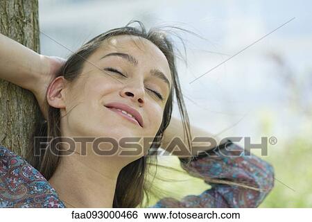 Stock Photograph - Woman relaxing outdoors, portrait. Fotosearch