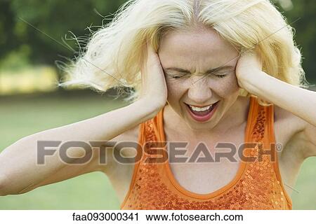 Woman screaming with eyes closed and hands over ears View Large Photo Image Stock Image - Woman screaming with eyes closed and hands over ears. Fotosearch
