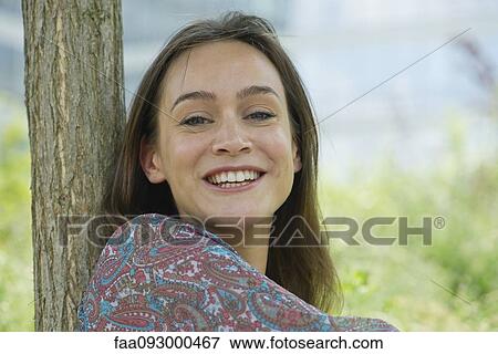 Stock Photo - Woman smiling outdoors, portrait. Fotosearch