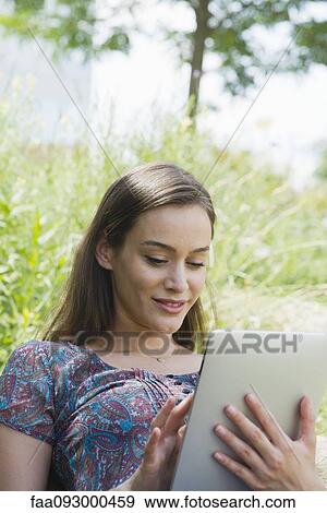Woman using digital tablet outdoors View Large Photo Image Stock Photo - Woman using digital tablet outdoors. Fotosearch
