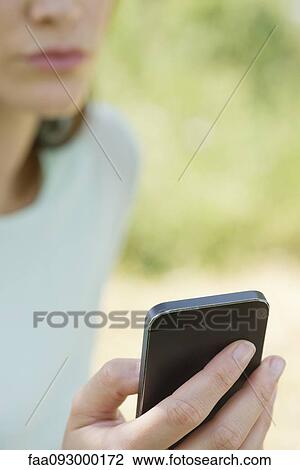 Woman using smartphone outdoors, cropped View Large Photo Image Stock Image - Woman using smartphone outdoors, cropped. Fotosearch