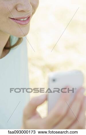 Woman using smartphone outdoors, cropped View Large Photo Image Stock Image - Woman using smartphone outdoors, cropped. Fotosearch