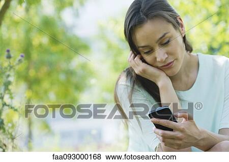 Stock Photo - Woman using smartphone outdoors. Fotosearch