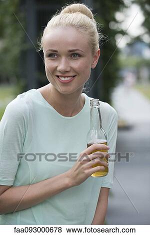 Stock Photo - Woman with beer at social gathering. Fotosearch