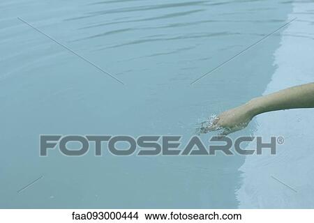 Picture - Woman's hand submerged in water. Fotosearch