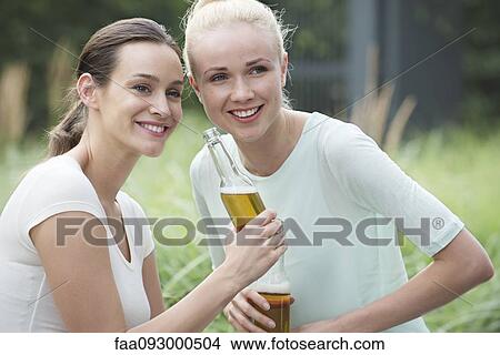 Picture - Women drinking beer together. Fotosearch