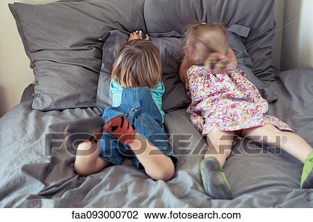 Young brother and sister lying together on bed View Large Photo Image Stock Image - Young brother and sister lying together on bed. Fotosearch
