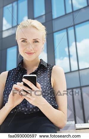 Young businesswoman using smartphone outdoors View Large Photo Image Stock Photo - Young businesswoman using smartphone outdoors. Fotosearch