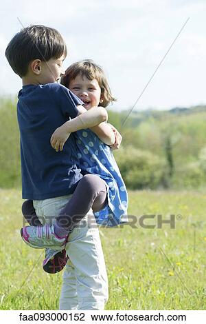Young siblings embracing outdoors View Large Photo Image Stock Image - Young siblings embracing outdoors. Fotosearch