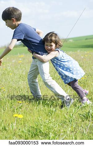 Young siblings playing together outdoors View Large Photo Image Stock Image - Young siblings playing together outdoors. Fotosearch