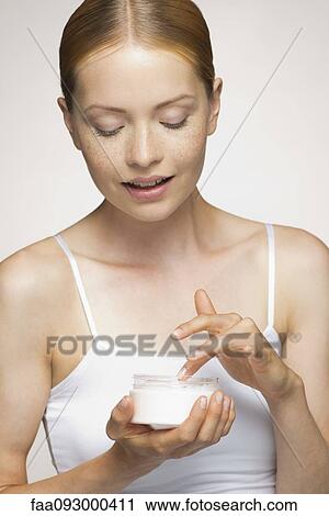 Young woman applying facial moisturizer View Large Photo Image Stock Image - Young woman applying facial moisturizer. Fotosearch