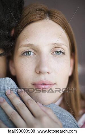 Stock Photo - Young woman embracing boyfriend. Fotosearch