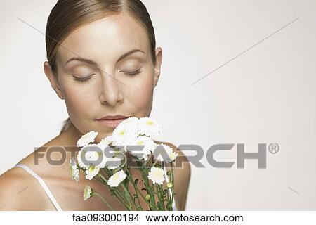 Young woman enjoying fragrence of bouquet of daisies View Large Photo Image Picture - Young woman enjoying fragrence of bouquet of daisies. Fotosearch