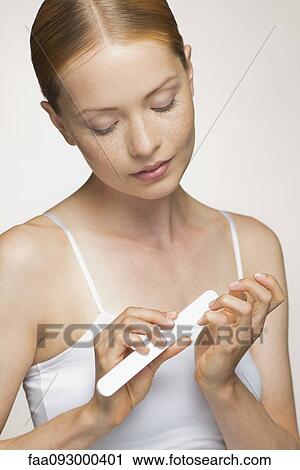 Young woman filing fingernails View Large Photo Image Stock Image - Young woman filing fingernails. Fotosearch
