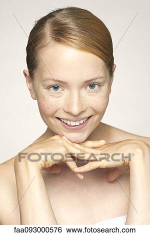 Stock Photograph - Young woman, hand under chin, portrait. Fotosearch