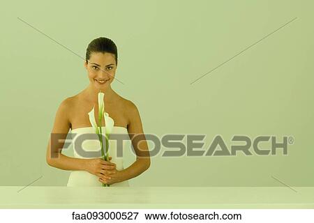 Young woman holding calla lilies, smiling at camera View Large Photo Image Stock Photo - Young woman holding calla lilies, smiling at camera. Fotosearch