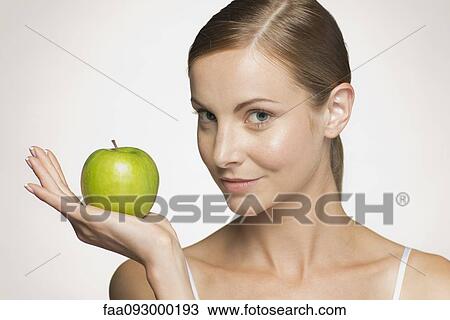 Young woman holding green apple View Large Photo Image Stock Image - Young woman holding green apple. Fotosearch