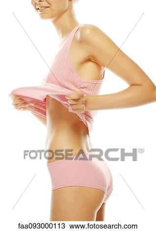 Young woman holding up shirt to show abdomen View Large Photo Image Stock Image - Young woman holding up shirt to show abdomen. Fotosearch