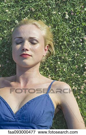 Young woman napping on grass, portrait View Large Photo Image Stock Photo - Young woman napping on grass, portrait. Fotosearch