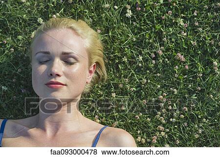 Young woman napping on grass, portrait View Large Photo Image Stock Photo - Young woman napping on grass, portrait. Fotosearch