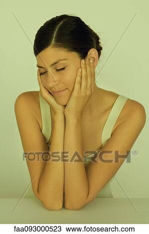 Young woman resting chin in hands, eyes closed, portrait View Large Photo Image Stock Image - Young woman resting chin in hands, eyes closed, portrait. Fotosearch
