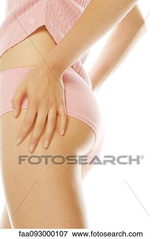 Stock Photo - Young woman standing in tanktop and underpants, hands on hips, mid section. Fotosearch