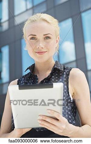 Young woman using digital tablet outdoors View Large Photo Image Stock Photograph - Young woman using digital tablet outdoors. Fotosearch