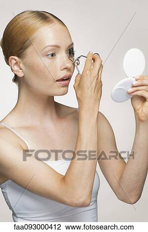 Young woman using eyelash curler View Large Photo Image Stock Image - Young woman using eyelash curler. Fotosearch