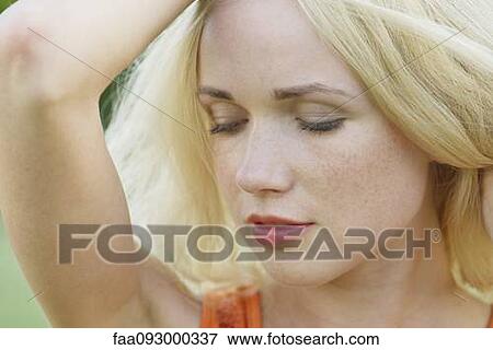 Stock Photo - Young woman with eyes closed, portrait. Fotosearch