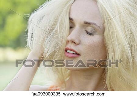 Young woman with hand in hair, eyes closed, portrait View Large Photo Image Stock Photography - Young woman with hand in hair, eyes closed, portrait. Fotosearch