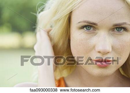 Stock Photo - Young woman with hand in hair, portrait. Fotosearch