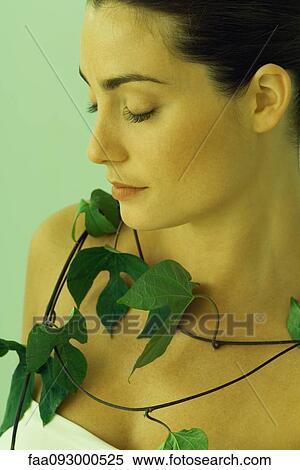 Stock Photography - Young woman with leafy vine around neck, close-up. Fotosearch