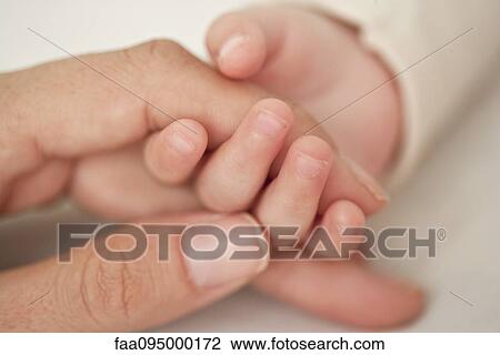Baby and mother holding hands, cropped, close-up View Large Photo Image Stock Image - Baby and mother holding hands, cropped, close-up. Fotosearch