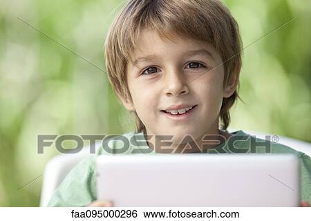 Boy holding digital tablet View Large Photo Image Stock Photograph - Boy holding digital tablet. Fotosearch