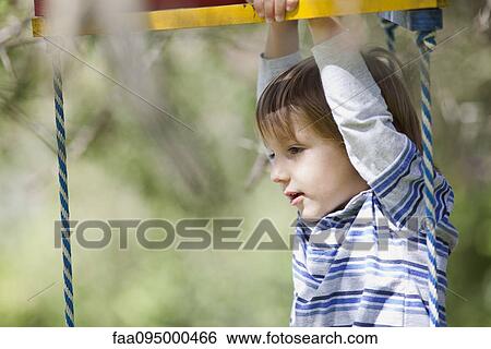 Stock Photograph - Boy playing on jungle gym. Fotosearch