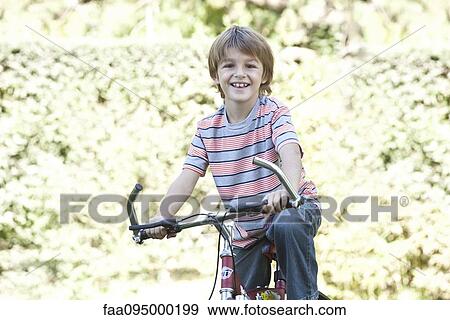 Boy riding bicycle View Large Photo Image Stock Photo - Boy riding bicycle. Fotosearch
